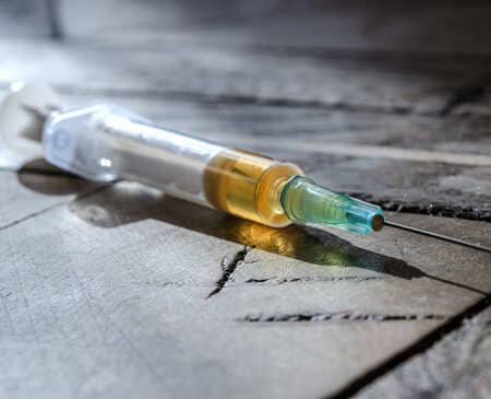 Шприц с желтой жидкостью